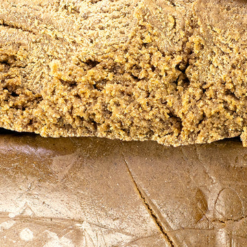 Close-up of solventless bubble hash showing granular structure and golden color